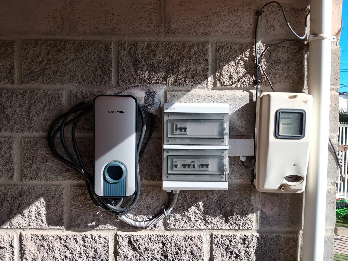 Cargador Livoltek junto a su tablero dedicado con protecciones, al lado del medidor de la casa